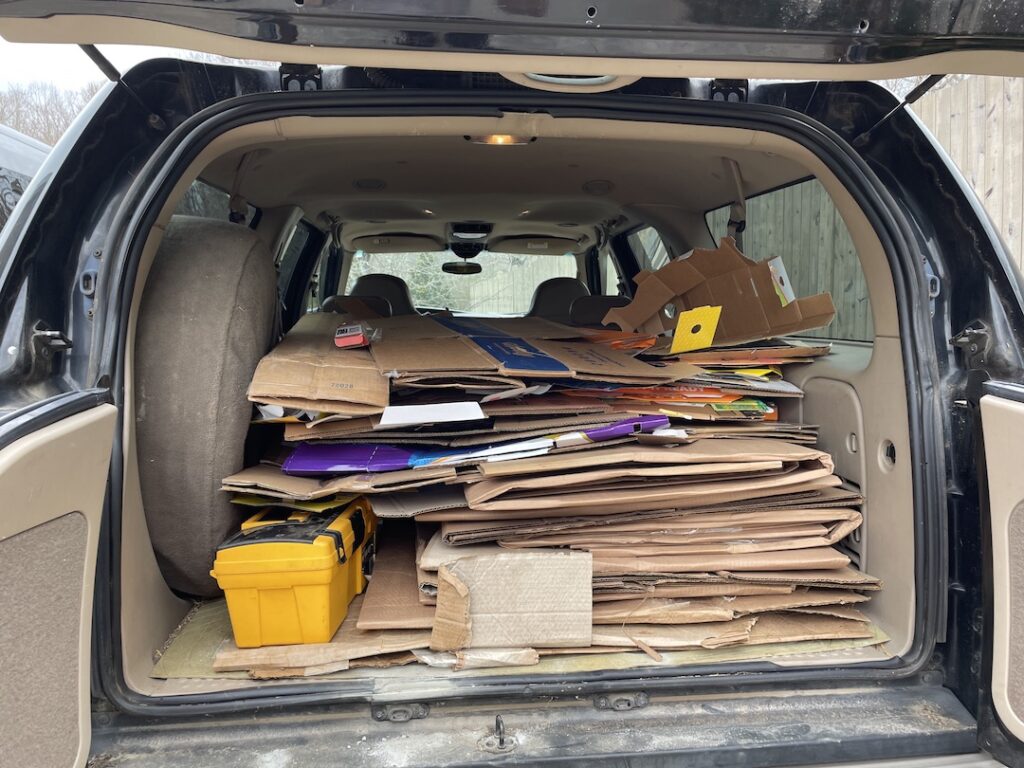 The inside of the rear compartment of our Excursion is nearly entirely full of stacked cardboard.