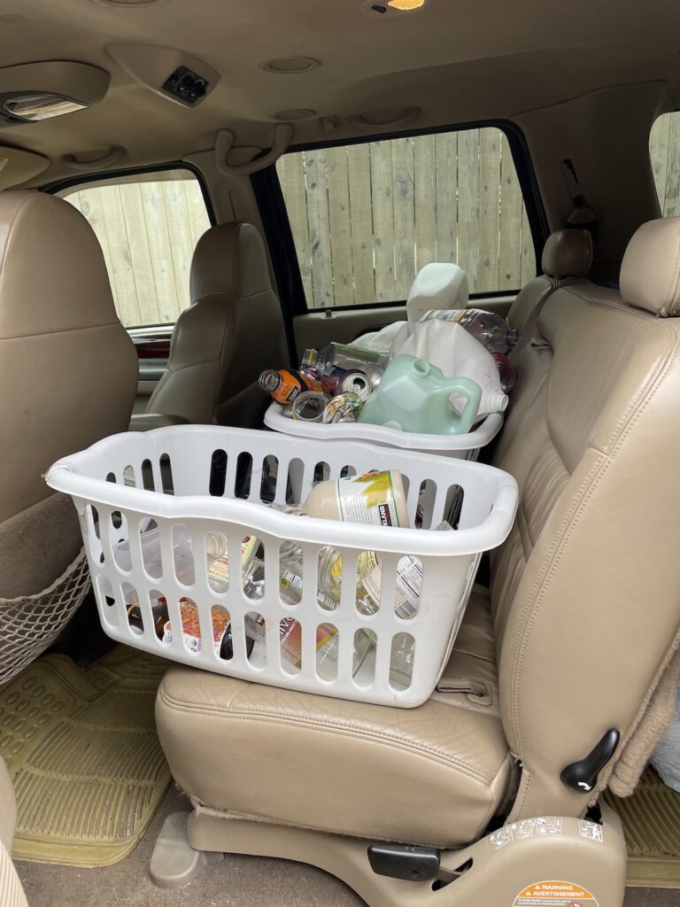 Glass, plastic, and aluminum are transported in laundry baskets placed in the back seat of the Excursion.