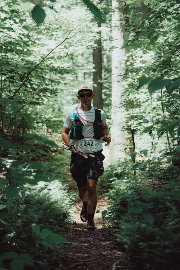 A picture of me running through the woods on a trail on a section of the flat creek loop