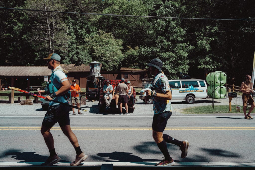 A photo of me and another runner running along a paved road between the Stanley Gap and Old Dial aid stations.